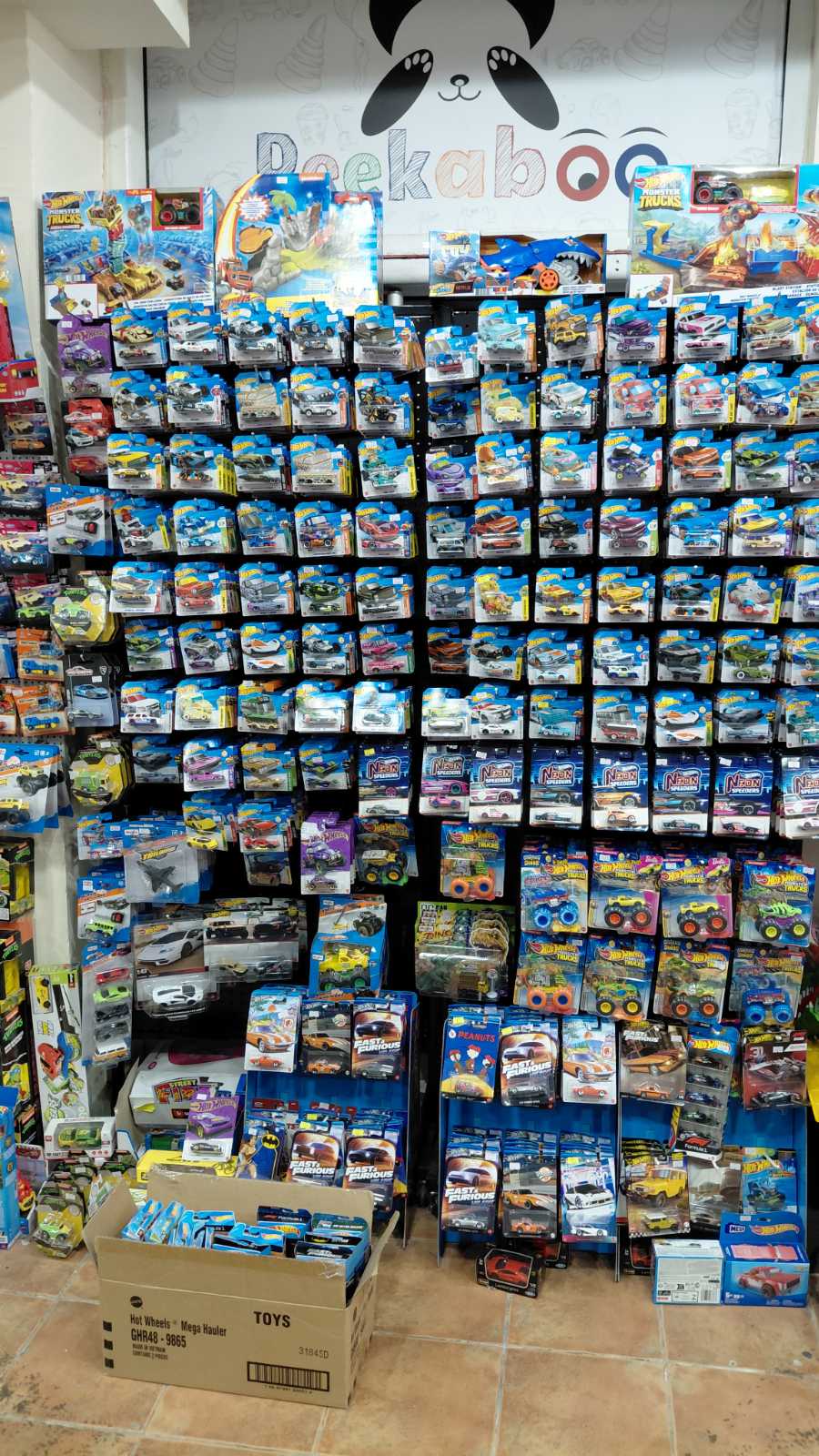 Полици со Hot Wheels автомобилчиња и Monster Trucks во продавница